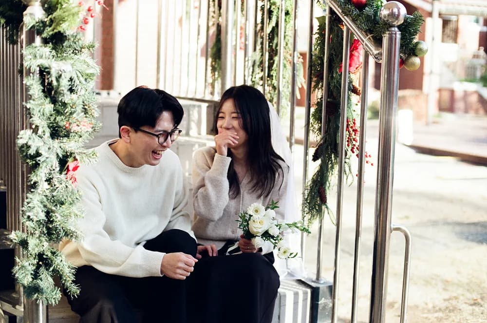 용산공원 미군장교숙소 단지에서 나란히 앉아 웃는 신랑 신부 야외 리허설 촬영