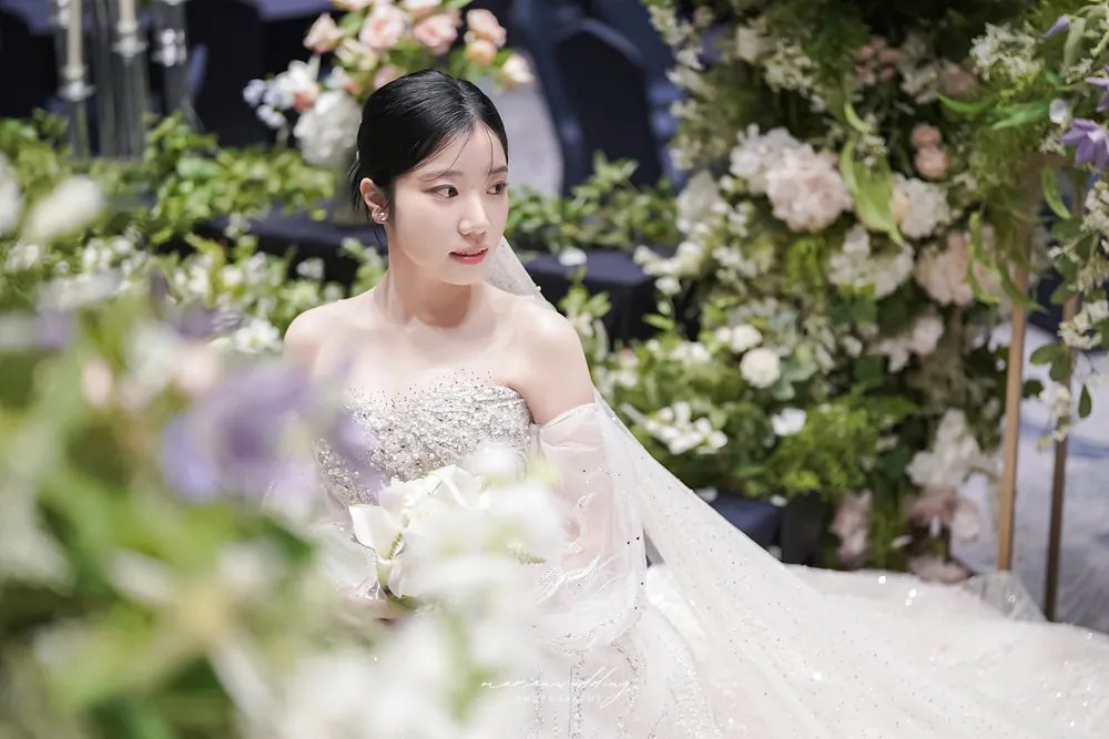 롯데리조트 예식장에서 생화에 둘러싸여 부케를 든 신부